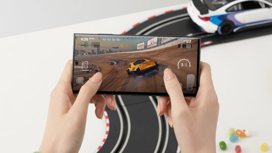 Samsung aktivt involverad i ray-tracing på mobilen: En reklambild av någon som spelar ett racingspel på Samsung Galaxy S23 Ultra.  Bakom dem står ett vitt bord med en fjärrstyrd bilbana på.