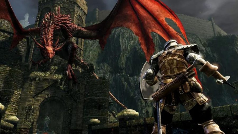En Dark Souls-riddare vänder sig mot en gigantisk röd wyvern på en borgvärn vid änden av en stenbro.