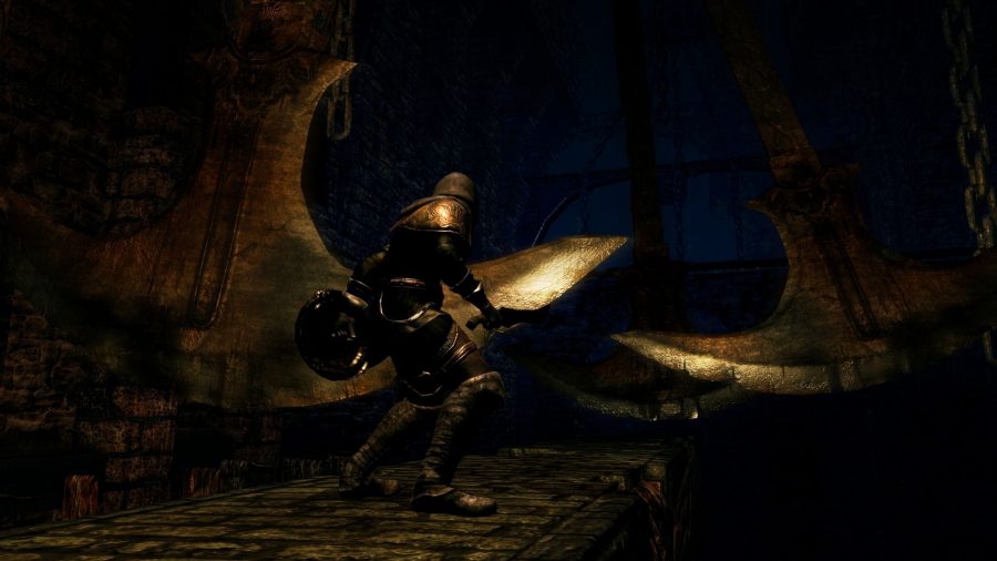 En Dark Souls-karaktär korsar en gångväg med svängande yxor ovanför.